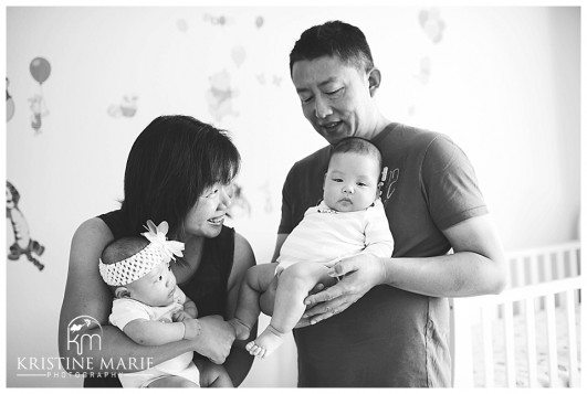 Candid Photo of Mom and Dad Holding Twin Babies in Nursery | San Diego Newborn Baby Photographer | Kristine Marie Photography