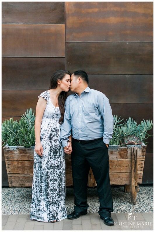 Cute couple kissing rustic wall succulents | Westfield UTC Mall Photos | La Jolla Engagement Photographer | Kristine Marie Photography © www.kristinemariephotography.com