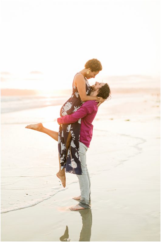 man lifting woman up for kiss Hotel Del coronado Beach Engagement Pictures San Diego Engagement Photographer Kristine Marie Photography