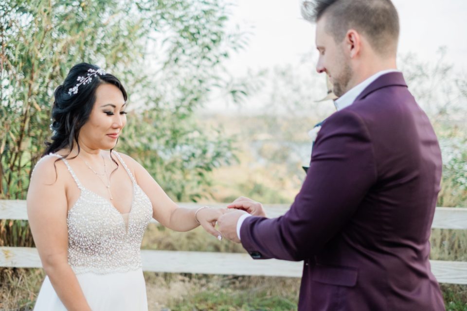 Groom puts wedding ring on bride's finger San Diego Elopement Photographer