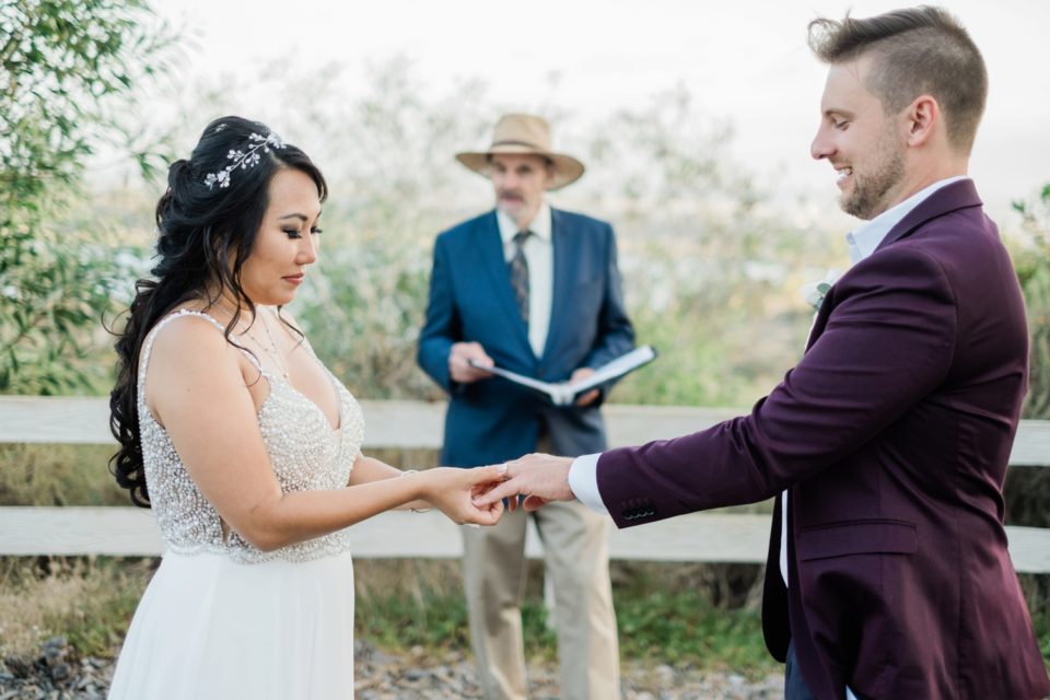 Bride putting wedding room on groom photo San Diego Elopement Photographer