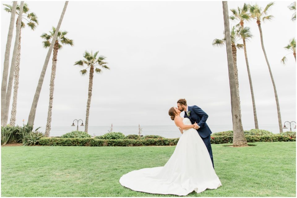 venue by the beach groom kissing bride photo | Ole Hanson Beach Club San Clemente Wedding Photographer | © Kristine Marie Photography